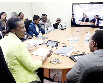 Rwanda Development Board CEO Valentine Rugwabiza (L) talks to KT officials via video link at the signing ceremony yesterday. The New Times/ John Mbanda.