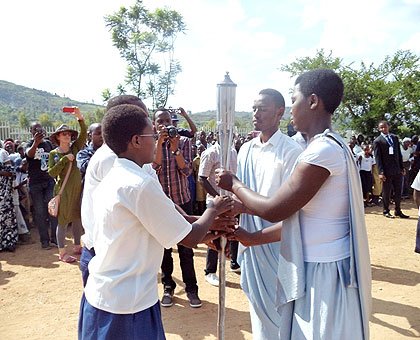 Students from Nyaruguru (L) hand over the Flame to those from Nyamagabe as the iconic torch of remembrance marked its ninth stop of the national tour. The New Times/ JP Bucyensenge.