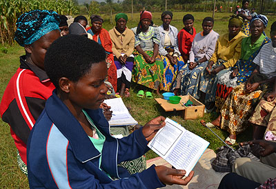 A woman shows how they record their money they save in individual booklets. Jean du2019Amour Mbonyinshuti. 