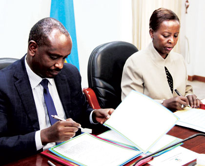 EAC Secretary General, Dr. Richard Sezibera (L), and Foreign Affairs minister, Louise Mushikiwabo, sign an agreement that allows Rwanda to host the EAC Science and Technology Commi....