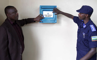 Deputy Ombudsman Clement Musangabatware (L) with the in- charge of Testing and Licensing in Traffic Police, Chief Sup. Rafiki Mujiji, fix an anti-corruption sticker on a confidenti....