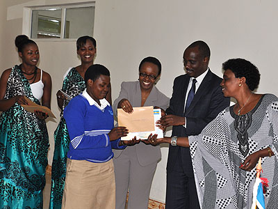  Muhongayire (R), Dr Sezibera and Haba hand a certificate to one of the winners, Delphine Uwamahoro, from Nyarutovu in Burera District. Athan Tashobya