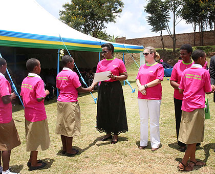 The First Lady, Jeannette Kagame, hands out certificates to some of the best performing school girls. On her immediate left is the Unicef country representative, Noala Skinner. Vil....