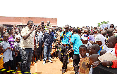 Bizimana (L)  and some of the NVYC members (in blue t-shirts) sensitise residents on malaria prevention.