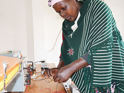 Uzamukunda arranges wires in her office. She is working with other rural women in distributing solar energy. (Jean du2019Amour Mbonyinshuti)