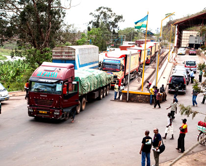 Trucks clear transit goods at Rusumo border post. Traders will in two years be able to use local currencies across EAC borders. File.