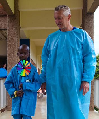 Dr David Andrews walks Moses Hirwa at KingFaisal Hospital after a heart operation. T. Kisambira.