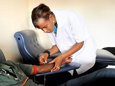 A Nurse takes blood samples from a patient. (Timothy Kisambira)