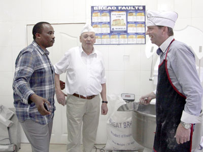 Murego (L) with staff inside his bakery. Product diversity is key in business. (Peterson Tumwebaze)