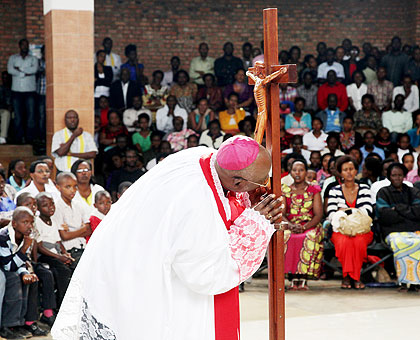 Archbishop of Kigali Thadeo Ntihinyurwa kisses the Cross at St Michel yesterday during the mass to observe Good Friday.  John Mbanda.