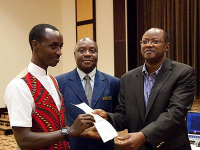 Silver Furaha (L) receives a certificate from Bart Gasana, the chairperson of tourism chamber at the Private Sector as Charles Muya looks on. (Timothy Kisambira)