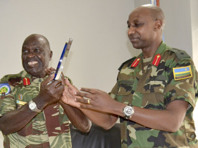 Col. Jill Rutaremara (R) offers a souvenir to Col. Sambulo Ndlovu. (Jean du2019Amour Mbonyinshuti)