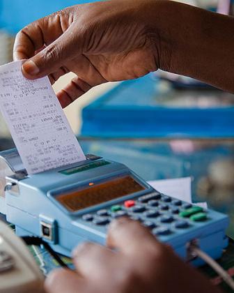 A trader in Quartier Matheus pulling a receipt out of the e-billing machine. File.