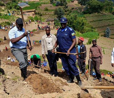 Prime Minister Habumuremyi (L), Gilbert Gumira, the Western Province Police commander, dig terraces during Umuganda in Nyabihu on Saturday. Jean du2019Amour Mbonyinshuti. Courtesy.