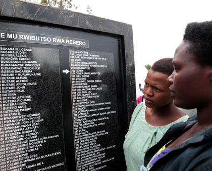 Young girls look at a memorial wall bearing names of Genocide victims at Rebero in Kigali in April. File.