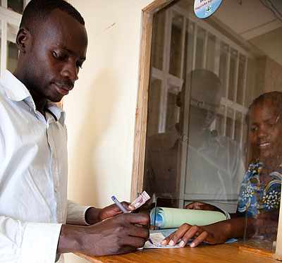 A client of Umerege Sacco in Kinyiya withdrawig money. The micro-finance sector is expected to be at the fore front of  the countryu2019s economic development. T.Kisambira. 