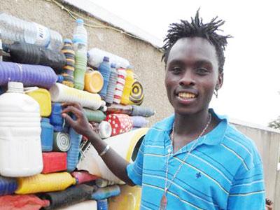 Timothy Wandulu poses by one of his pieces made from scrap. (Moses Opobo)