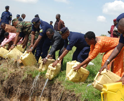 Police officials and local leaders destroy illicit liquors during a campaign against the beverages last year.. File.