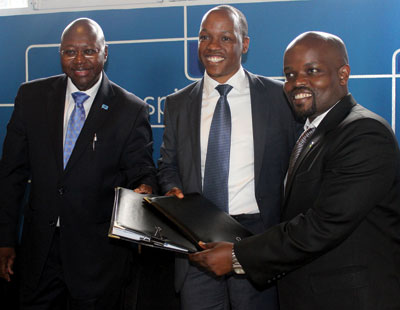 Nsengimana (right) joins Manneh (left) and Maramba as the two exchange the deal documents on Wednesday.   The New Times / Ben Gasore