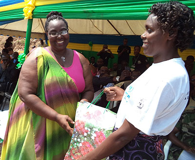 Minister Mukantabana hands a gift to Donata Umulisa, one of the refugees who were recognised for striving to improve the lives of others. Jean Pierre Bucyensenge.