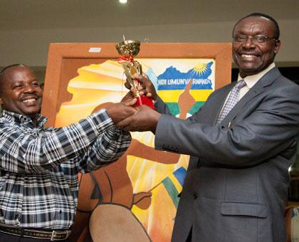 Gerald Sendashonga (L), a leather craftsman, receives an award from trade and industry minister Franu00e7ois Kanimba. Exports of crfats could bridge the gap left by falling prices of ....