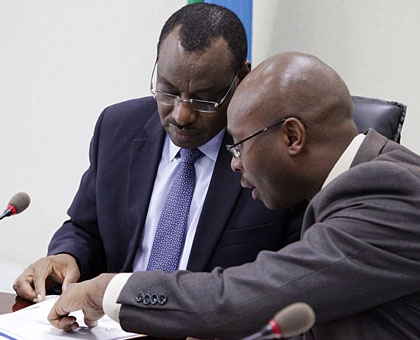 Finance and Economic Planning minister Claver Gatete (L) and NISR director-general Yusuf Murangwa examine a document during the media briefing yesterday. John Mbanda. 