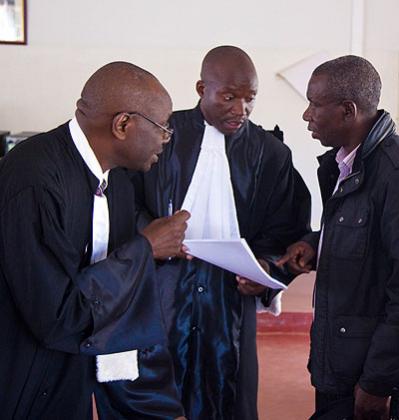 Bandora (R) talks to his lawyers Mbera Ferdinand (L) and Nizeyimana after the court session. Timothy Kisambira.