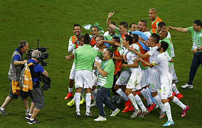 Algeria's national soccer team celebrates in front of the camera after their 2014 World Cup Group H soccer match against Russia at the Baixada arena in Curitiba on Thursday