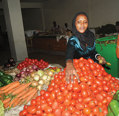 A vendor in Kimironko market arranges her stall. The prices of carrots, green pepper, among other vegetables have gone by up to Rwf200 in most markets across the city. 