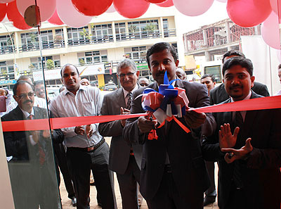 Krishnan (L) cuts the opening ribbon as Riyaz,  the head of operations at UAExchange Rwanda.(R) looks on.