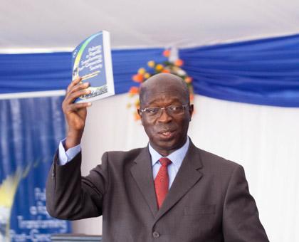 Prime Minister Anastase Murekezi lifting the Police Book after the launch. (Timothy Kisambira)