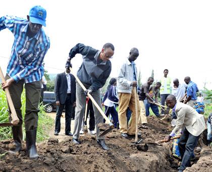 President Kagame digs a trench in Cyeru during Umuganda. (Timothy Kisambira)