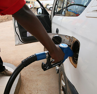 A pump attendant refills a car at a gas station. The East African Community plans to adopt cleaner fuel standards in 2015. File.