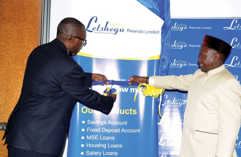 Central banku00e2u20acu2122s Gatera (left) cuts the tape to launch the service. (Peterson Tumwebaze)