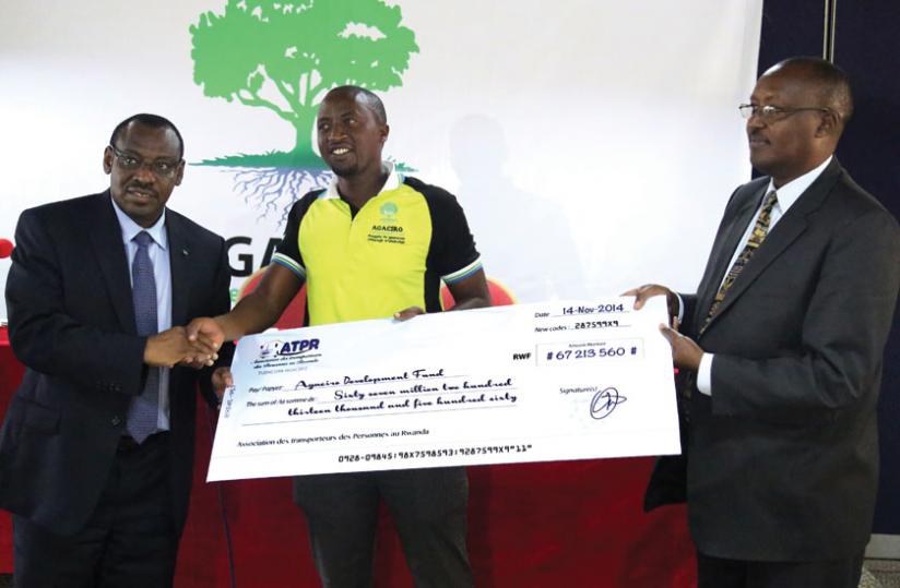 Gatete and Agaciro Fund boss Vianney Kagabo (left) receive a dummy cheque from ATPR boss Nizeyimana (centre). (John Mbanda)