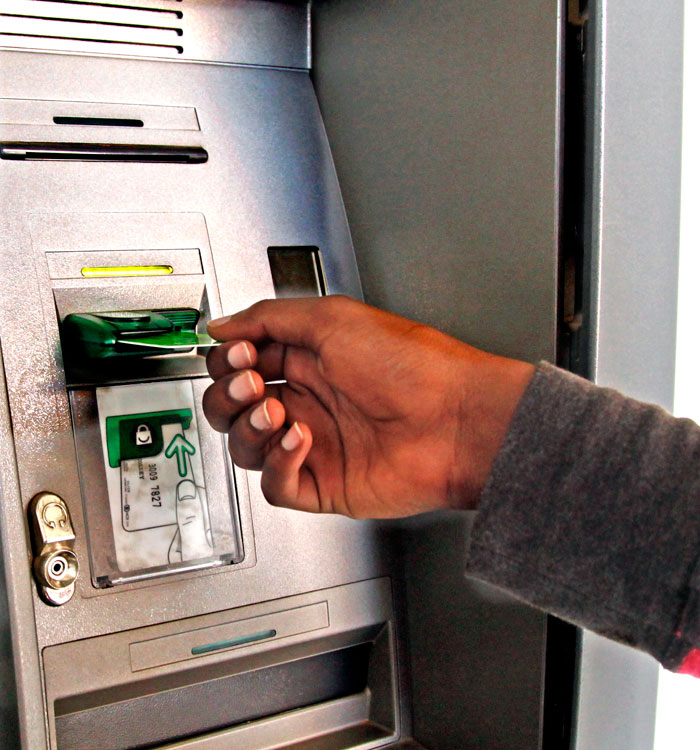 A client withdraws money from an ATM machine. (Timothy Kisambira)