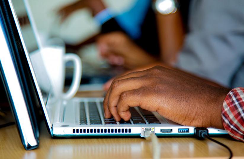 A man surfs the Internet using a laptop computer. Most local businesses still prefer to host their servers on foreign domains. (Timothy Kisambira)