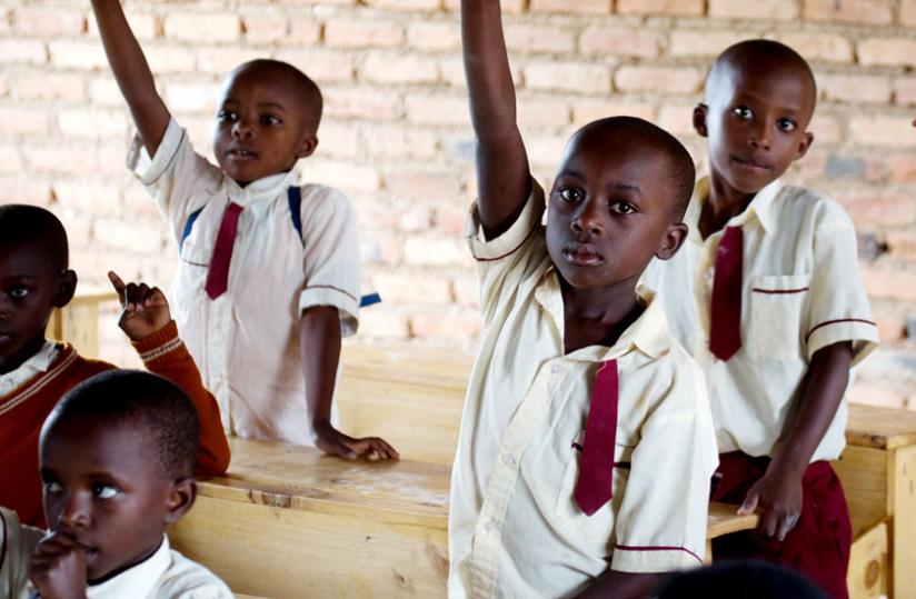 Pupils of Rusheshe Primary School raise their hands to answer a question in class earlier this week. (File)