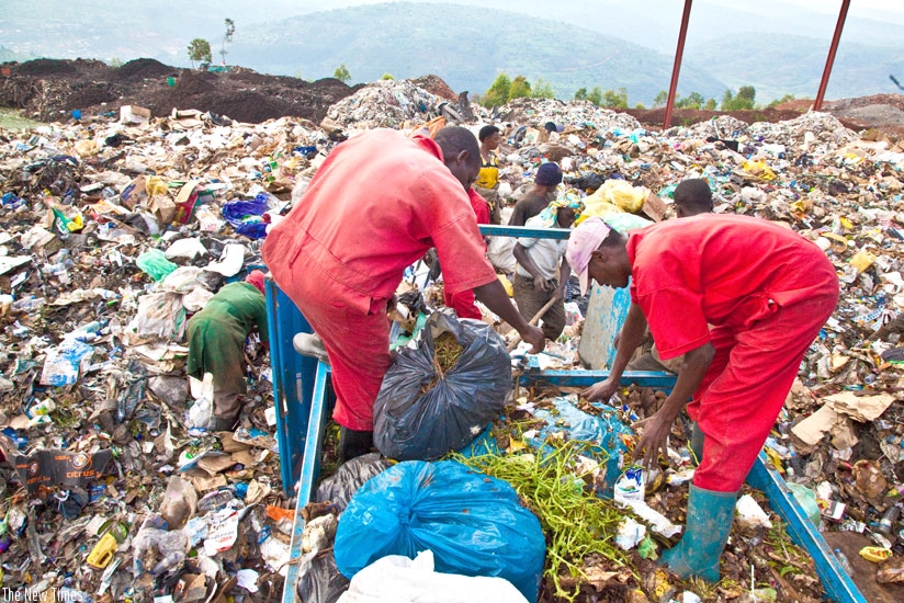 Workers at Nduba dumping site in Gasabo District offload Garbage recently. (Timothy Kisambira)