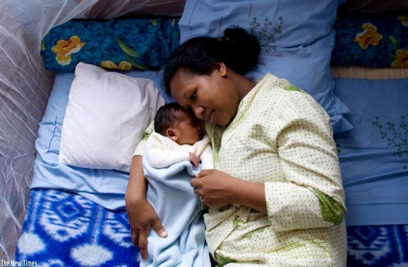 A mother cuddles her baby. (Net)