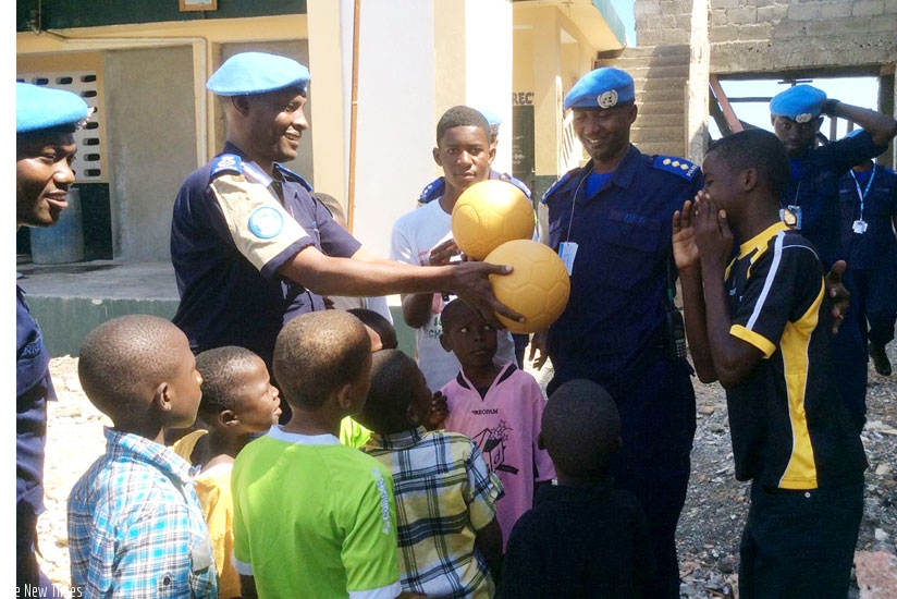 Munyambo hands over balls to an orphan. (Courtesy)