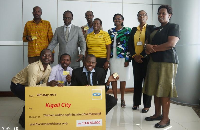 City of Kigali mayor Fidele Ndayisaba (second left, standing) poses for a picture with beneficiary school heads and MTN Rwanda officials. (Courtesy)