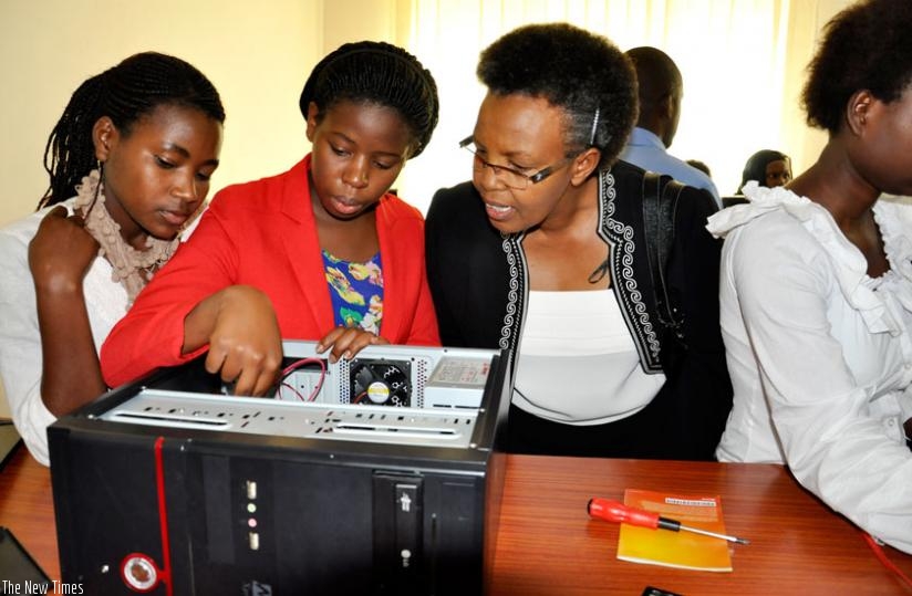 Rita Zirimwabagabo, the vice-president of Imbuto Foundation (R), watches one of the Imbuto-funded ICT female students repair a computer at the closure of a three-week training in ICT for 28 female students at Tumba College of Technology in Rulindo District on Friday. (Placide Hagenimana)