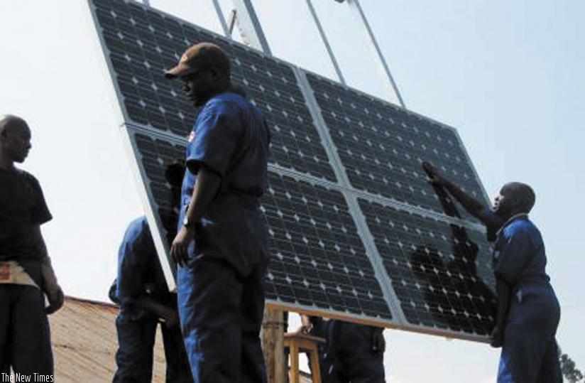 Technicians install a solar panel. Green energy users are able to reduce energy bills.