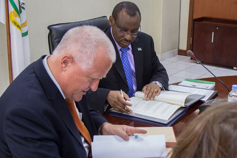 Finance Minister Claver Gatete (R) signs documents with the German Ambassador to Rwanda, Peter Fanrenholtz, yesterday. (Timothy Kisambira)