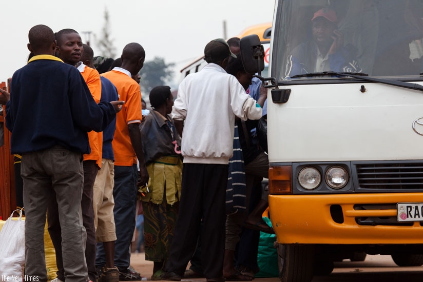 Passengers enter a bus at Nyabugogo bus terminal. (Timothy Kisambira)