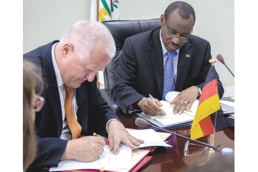 Amb. Fahrenholtz (L) and Minister Gatete sign the funding agreements in Kigali yesterday. (All photos by Timothy Kisambira)