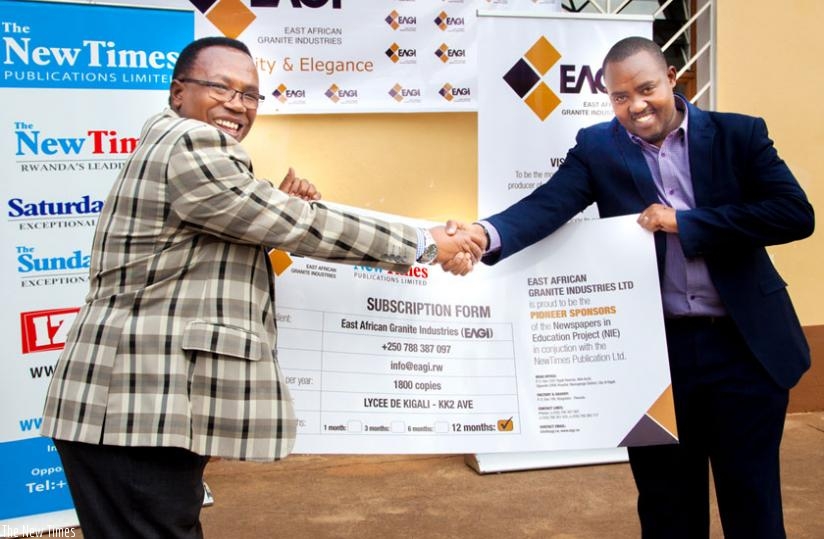 Lycee de Kigali's headmaster Martin Masabo (left) and East African Granite Industries' general manager Andrew Kulayige present the agreement to the public after the latter signed a partnership with The New Times Publications to supply the paper to the school daily.