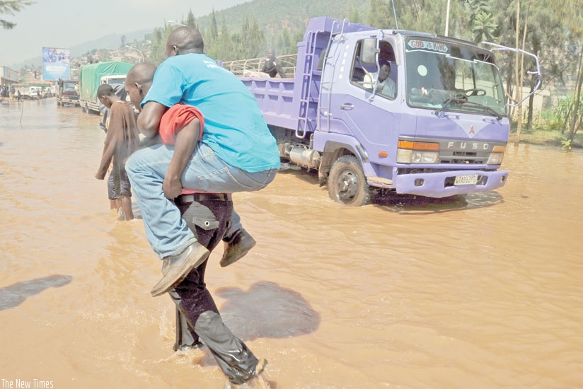 A man is carried across a flooded road in Nyabugogo, a Kigali City suburb. (File)