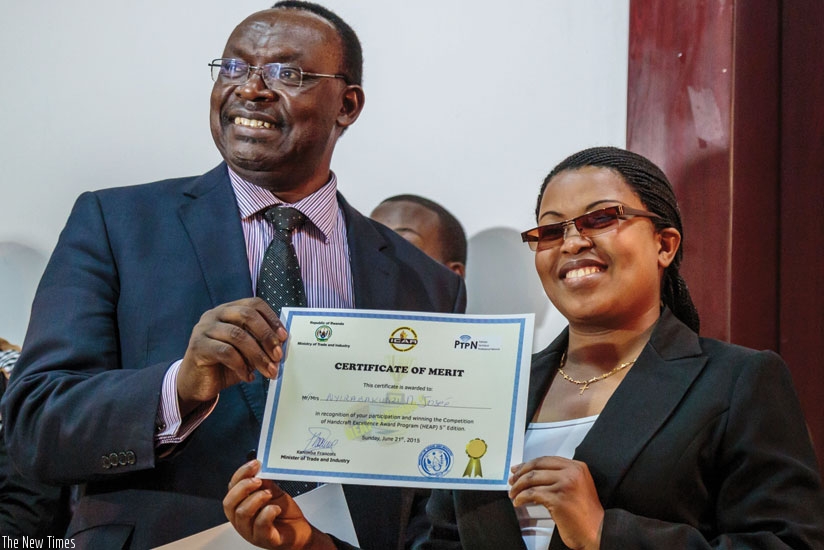 Marie Josee Nyirabakunzi, a basket weaver from Huye District, receives a certificate from Trade and Industry Minister Kanimba at the just-ended regional artisans expo in Kigali. (Timothy Kisambira)